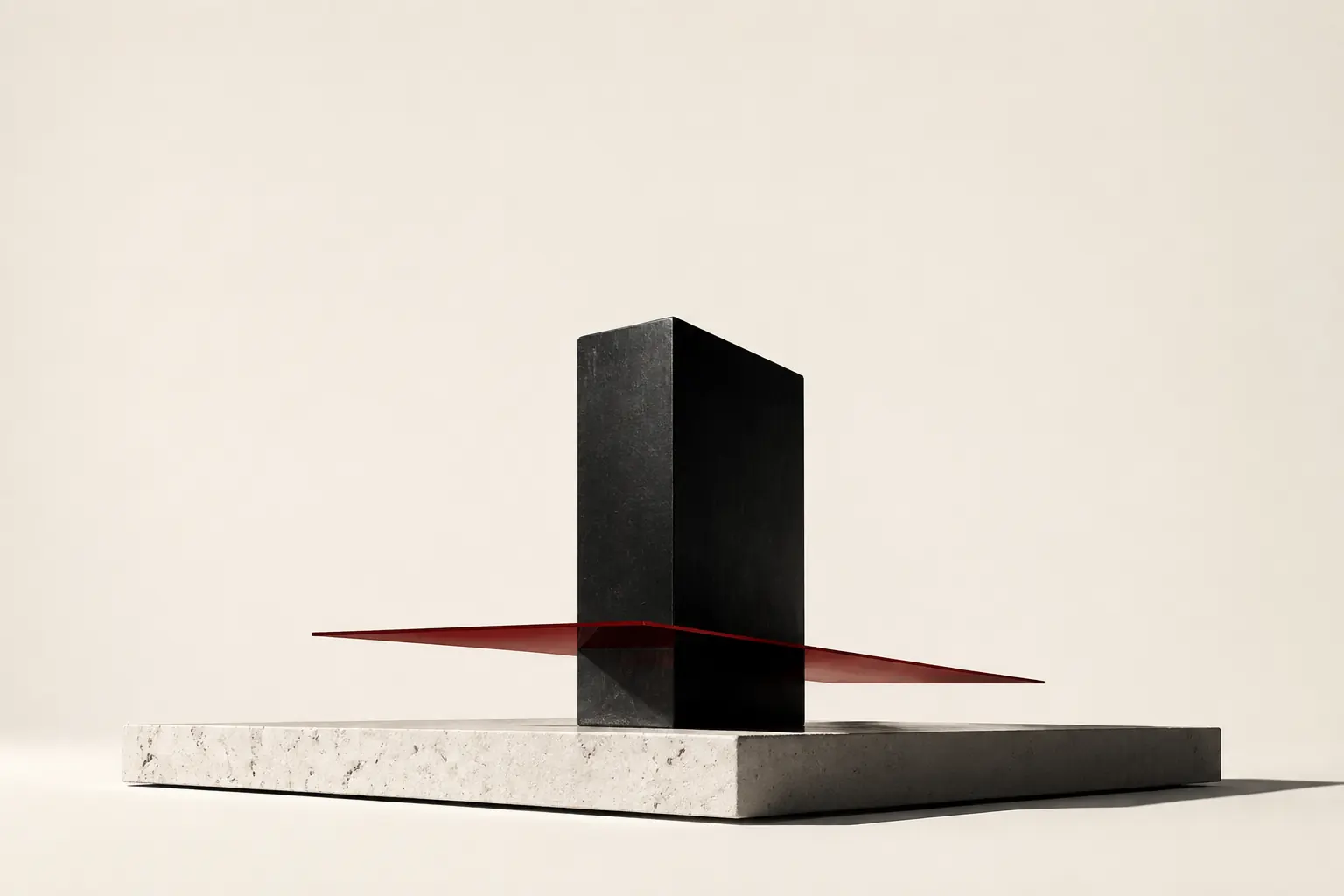 Conceptual sculpture of dark stone and a deep red plane on limestone